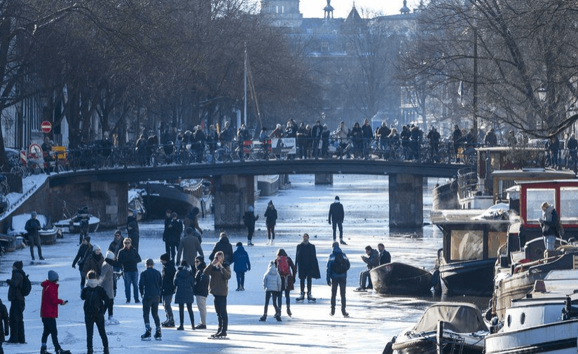 Amsterdam ice 2021 a group of people riding skis on a snowy street