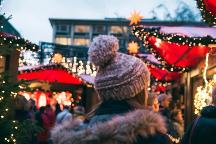 tourist standing in front of Cologne Christmas market facing away
