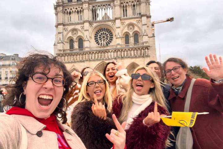 Group of people taking a selfie in front of a large cathedral.