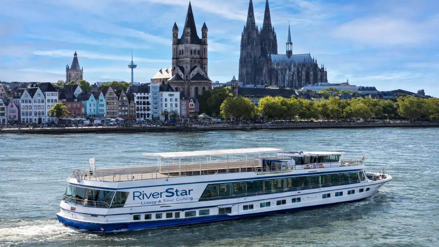 Rhine cruise boat passing Cologne skyline with cathedral on the Rhine River