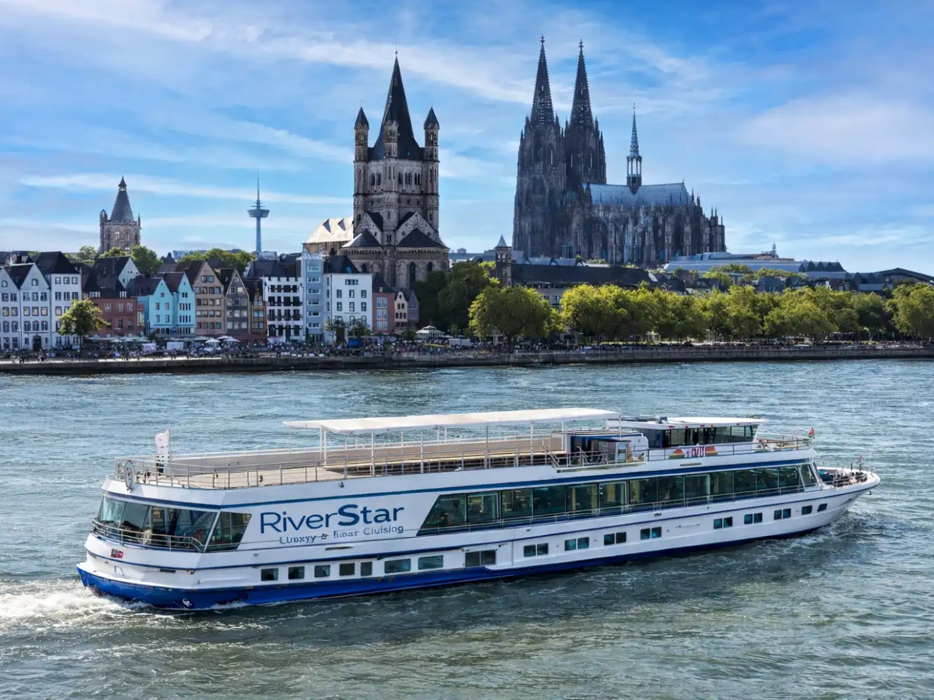 Rhine cruise boat passing Cologne skyline with cathedral on the Rhine River