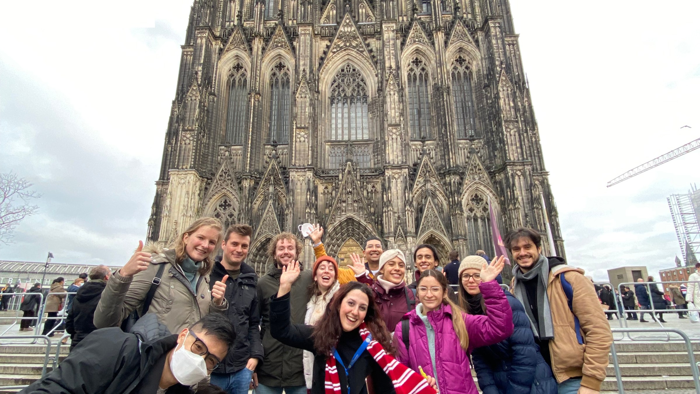 Group of people posing in front of a large Gothic cathedral.