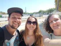 Three people smiling with the Eiffel Tower in the background.